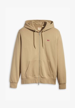 Sudadera con cremallera beige hecha de una tela suave. Cuenta con una capucha grande, bolsillos frontales y un logo rojo de Levi's en el pecho.
