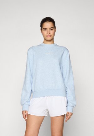 Light blue sweatshirt made of soft fabric with a round neckline, ribbed cuffs, and a small logo detail on the chest; paired with white shorts.