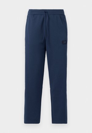 Navy blue jogger pants made of soft cotton blend, featuring an elastic waistband with drawstring and a small branded patch on the hip.