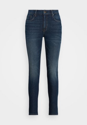 Ciemnoniebieskie spodnie jeans o dopasowanym kroju, z pięcioma kieszeniami, zapinane na guziki, z delikatnym wyblednięciem na udach i kolanach.