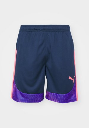 Puma-Sportshorts mit elastischem Bund, aus navyblauem Stoff, mit rosa Side-Akzenten und einem lila gemusterten Saum.