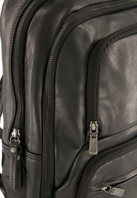 Czarny skórzany plecak z wieloma zamykanymi na zamek komorami, teksturowaną powierzchnią i akcentami z srebrnego metalu dla dodatkowego efektu.