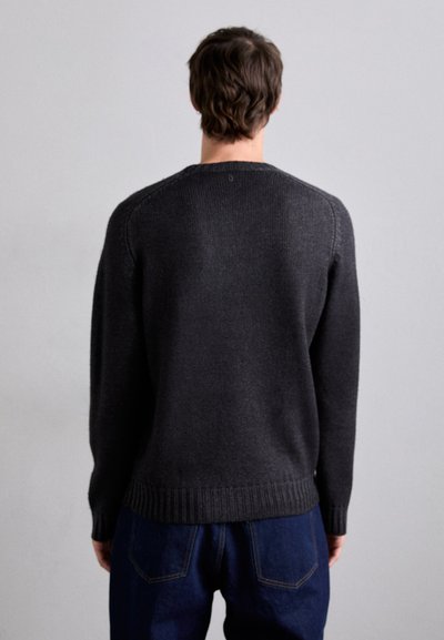 Dark gray knit sweater with long sleeves, ribbed cuffs and hem, featuring a round neckline and subtle texture. Worn over blue jeans.