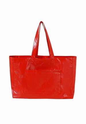 Grand sac fourre-tout rouge brillant avec deux poignées et une poche avant, conçu pour transporter des objets.