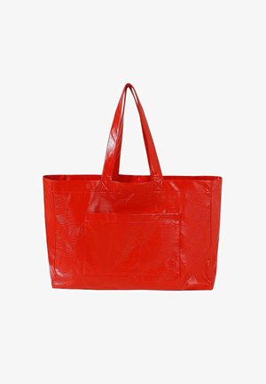 Grand sac fourre-tout rouge brillant avec deux poignées et une poche avant, conçu pour transporter des objets.