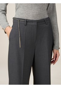 Los pantalones de vestir gris carbón tienen un detalle de cadena en la cintura, un tejido texturizado y un diseño de pierna recta con bolsillos.