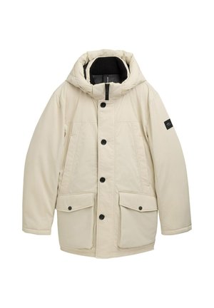 Beige pufferjack met een capuchon, voorzien van een front rits, zwarte knopen, twee voorste klepzakken en een geribbelde kraag.