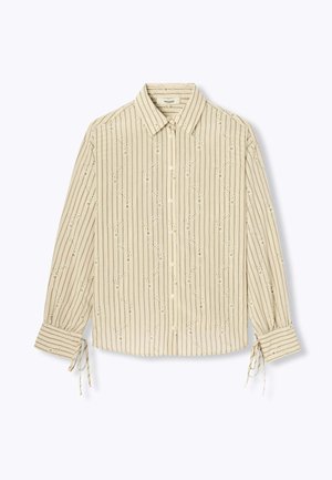 Blouse beige à manches longues avec rayures verticales, petites broderies florales, fermeture par boutons à l'avant, col, et détails noués aux poignets.