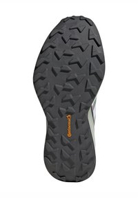 Semelle de chaussure en caoutchouc noir avec des motifs de sculpture multidirectionnels profonds. Présente le logo Continental en orange et une surface texturée pour une meilleure adhérence.