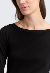 Schwarzes Langarmshirt mit weitem Ausschnitt, aus weichem, dehnbarem Stoff gefertigt, mit glatter Textur und figurbetontem Schnitt.