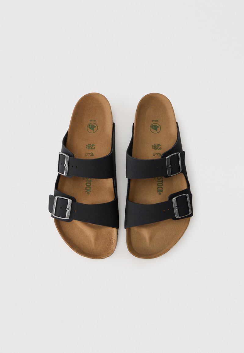 Schwarze Rutschsandalen mit zwei verstellbaren Riemen und silbernen Schnallen. Korkfußbett mit glatter Oberfläche, flache Sohle. Minimalistisches Design, Gummisohle.