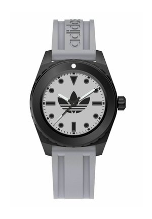 Montre noire avec un grand cadran rond, un cadran gris, des aiguilles blanches et un logo Adidas bien visible, soutenue par un bracelet en caoutchouc gris.
