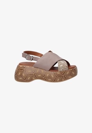Light brown leather sandal with a crisscross design, adjustable ankle strap, and a geometric patterned platform sole in tan and cream.
