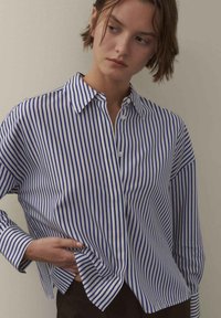Blau-weiß gestreiftes Hemd mit Knopfleiste, klassischem Kragen, langen Ärmeln und leicht lockerem Sitz, aus glattem Baumwollstoff gefertigt.