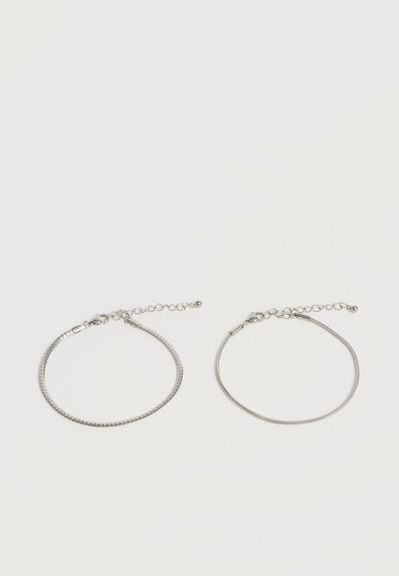 Δύο ρυθμιζόμενα ασημένια βραχιόλια με διαφορετικά σχέδια αλυσίδας σε λευκό φόντο, και τα δύο με κούμπωμα τύπου αστακού.