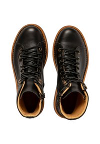 Botas de cuero negro con un interior de cuero marrón claro, con cordones negros, ojetes de metal y una suela de goma marrón de contraste.