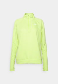 Długi rękaw, półzippowy polar w jaskrawym neonowym żółtym kolorze o gładkiej teksturze. Posiada białe logo Nike na lewej piersi.