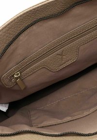 Beige Lederhandtasche mit einem Reißverschlussfach und glattem Innenfutter; hat eine strukturierte Außenfläche und einen dunklen Reißverschluss.