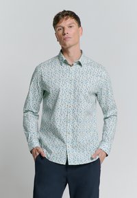 Hellblaues Hemd mit Knopfleiste und geometrischem Muster in dunklerem Blau und Creme. Hergestellt aus glattem Stoff mit langen Ärmeln.