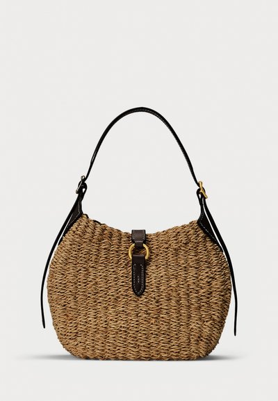 Geweven stro-handtas met een zwart lederen bovenhandvat, een leren riem met gouden gesp aan de voorkant en een getextureerd afgerond lichaam.