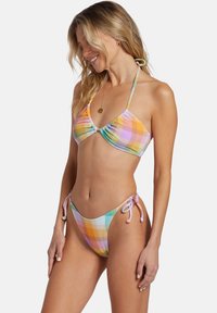 Bunt gekacheltes Bikini-Set aus weichem Stoff, mit einem gebundenen Haltertop und verstellbaren Seitenbändern am Unterteil, in sanften Pastellfarben.