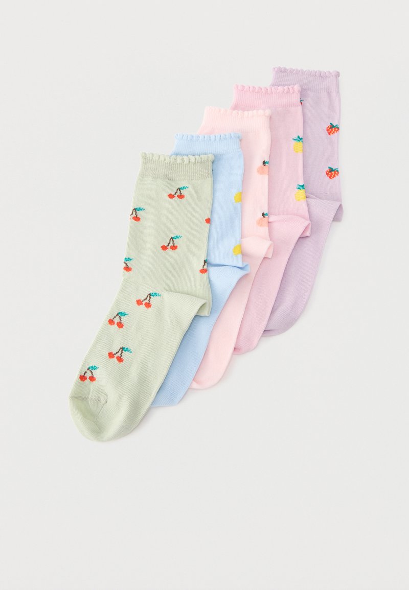 Cinq paires de chaussettes pastel avec des motifs de fruits, incluant cerises, citrons, pêches, ananas et fraises, disposées en rangée.
