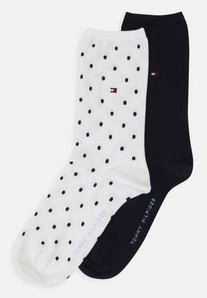 Lot de chaussettes en coton : une noire, une blanche avec des pois noirs. Chaque paire arbore le logo "Tommy Hilfiger" près de la cheville. Design et coupe classiques.