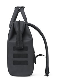 Sac à dos noir en matériau lisse et imperméable, avec une fermeture à glissière, des bretelles réglables et trois sangles de webbing horizontales sur le côté.