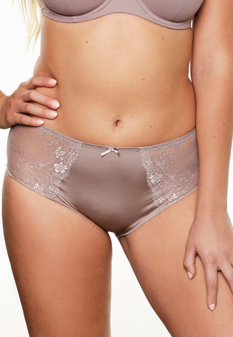 Culotte en dentelle beige avec un devant en satin lisse et des panneaux latéraux en dentelle florale. Fini par un petit nœud en satin à la taille.