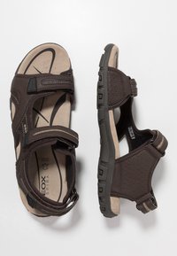 Bruna sandaler med justerbara remmar, perforerade sidor, en formad innersula och en tjock gummisula med grepp.
