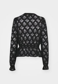 Schwarze Spitzenbluse mit langen Ärmeln, Peplum-Taille und einem Diamantmuster. Transparente Textur mit gemufften Ärmeln und rundem Halsausschnitt.