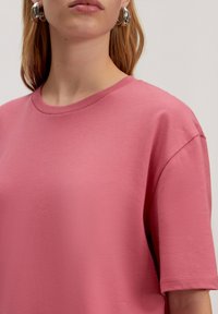 Roze katoenen T-shirt met een ronde halslijn, korte mouwen en een soepele textuur, met een relaxte pasvorm en zonder zichtbare patronen of accenten.