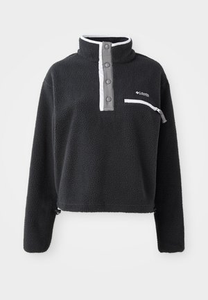 Black fleece pullover with a half zip collar, featuring a front chest pocket and contrasting white and gray accents. Soft texture, cropped design.