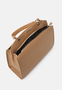 Sac à main en cuir beige avec poignée festonnée, compartiment principal à fermeture éclair et doublure intérieure imprimée léopard, marqué "Liu Jo" sur la bordure supérieure.