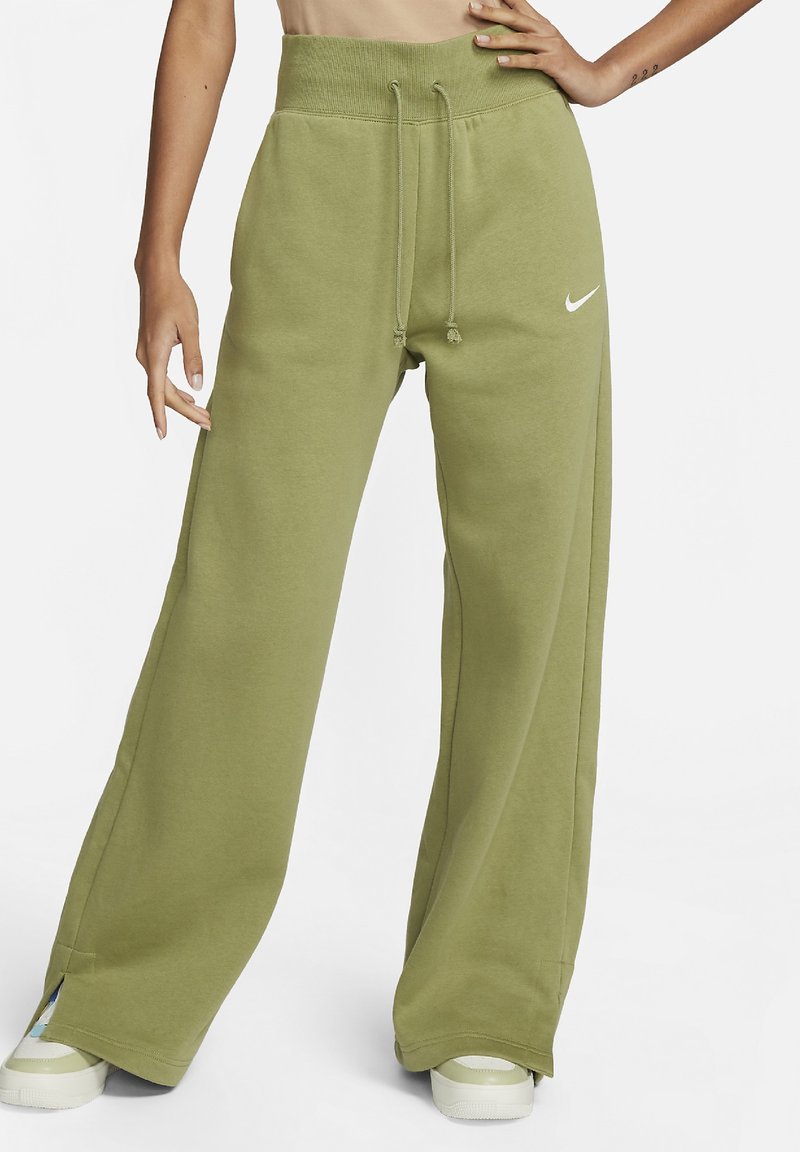 Pantalon de survêtement vert olive à jambes larges, taille avec cordon de serrage, haut côtelé et petit logo Nike blanc sur le côté gauche.