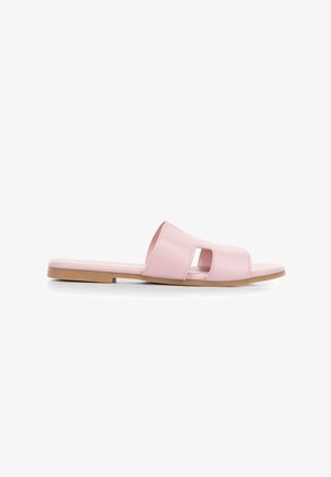Sandalo flat rosa con punta aperta, due fascette ritagliate e una suola sottile marrone su sfondo bianco.
