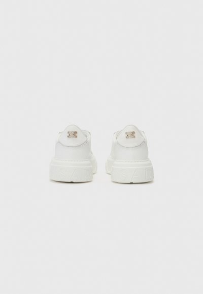 Vita sneakers med en texturerad sula, med en subtil präglad logotyp på häl och en slät syntetisk överdel.