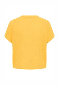 Kortærmet gul top med tekstureret stof, lige snit og en diskret knapdetalje bagpå. Let og åndbar design.