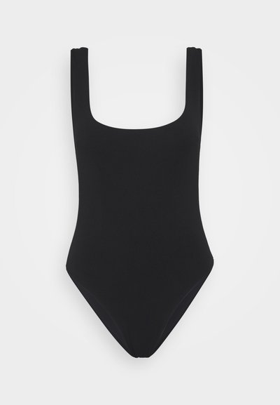 Mustmust kaasüpäevitus, millel on ruudukujuline kaelus, laiad õlapaelad, kõrghoiakuga jalad ning sile, veniv kangas. Minimalistlik disain ilma mustriteta.