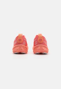 Helle korallenfarbene Sportschuhe mit einer strukturierten Oberfläche, verstärkten Fersentabs und weißer Sohle. Merkmale sind Logo-Akzente und ein marmoriertes Design.