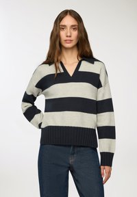 Sweter w paski w jasnoszarym i granatowym kolorze, z dekoltem w serek i prążkowanym wykończeniem. Długie rękawy, miękka tekstura i kołnierzyk podkreślają jego styl.