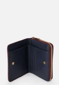 Marine lærveske med burgunder detaljer, gullglidelås og flere kortspor. Glatt tekstur med preget logo-detalj.