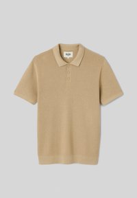 Polo tricots beige à manches courtes avec trois boutons, devant texturé, col, poignets et bas en bord-côtes.