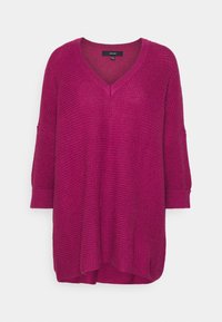 Pull en tricot fuchsia avec encolure en V, manches trois-quarts et poignets côtelés. Coupe ample avec un motif texturé sur toute la surface.