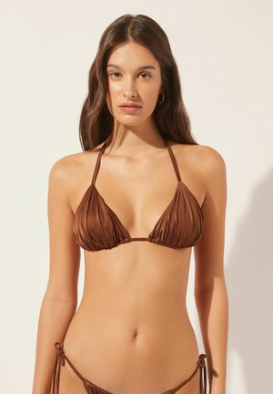 Brązowy biustonosz bikini w kształcie trójkąta z fałdowanym wykończeniem, regulowanymi ramiączkami i minimalistycznym zapięciem. Akcentowany dopasowanymi wiązaniami po bokach.
