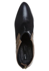 Bottine en cuir noir avec bout pointu et panneaux latéraux élastiques marron, vue de dessus.