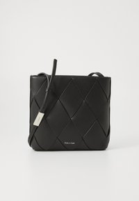 Borsa a tracolla in pelle nera con design intrecciato, forma rettangolare, una tracolla e una piccola etichetta logo argentata sul davanti.