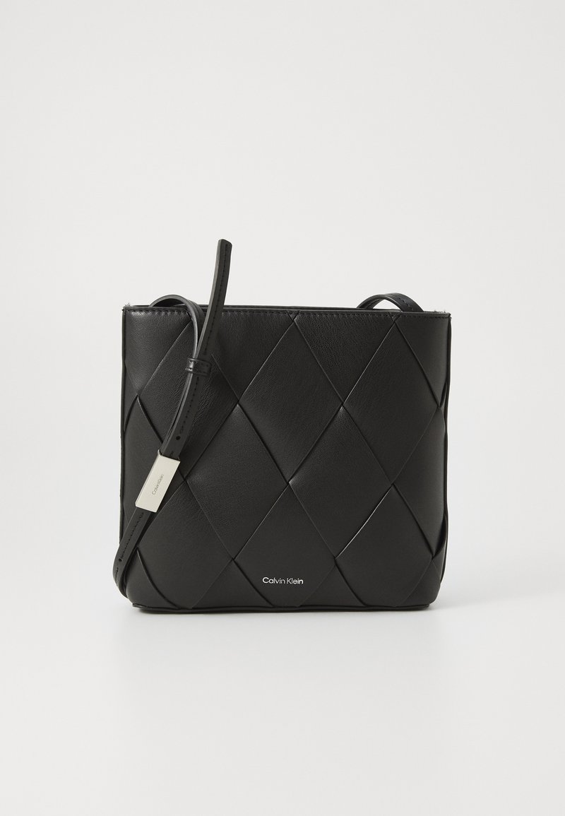 Borsa a tracolla in pelle nera con design intrecciato, forma rettangolare, una tracolla e una piccola etichetta logo argentata sul davanti.