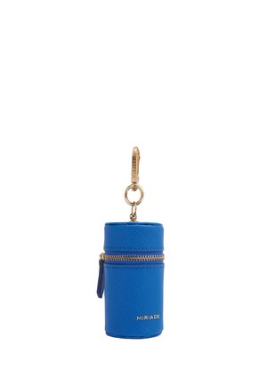 Custodia cilindrica in pelle blu con cerniera e clip dorati, con il nome del marchio "MIRIADE" in lettere dorate.