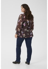 Floral blouse in dark brown with puffed sleeves, sheer fabric, and ribbed texture; paired with dark blue jeans and black shoes.